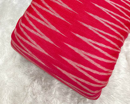 Red pillow with white stripes on a white fluffy surface