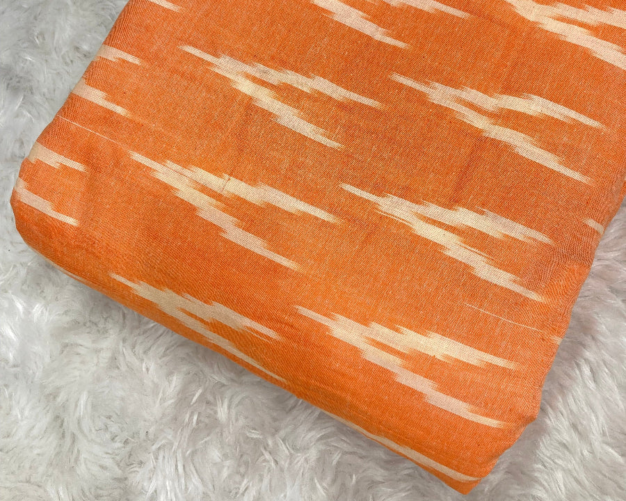 Orange fabric with white pattern on a textured gray surface