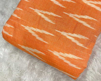 Orange fabric with white pattern on a textured gray surface