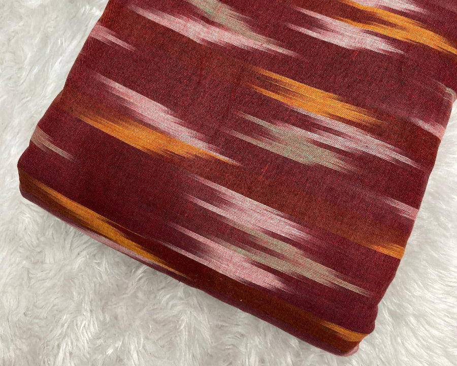 Fabric with a pattern of red, orange, and white on a textured white background