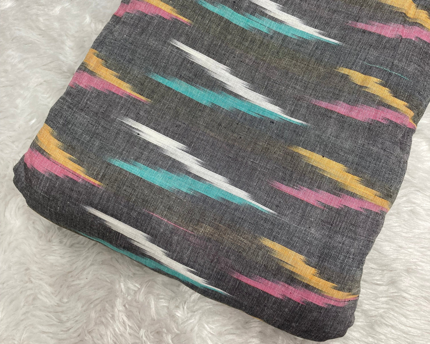 Folded fabric with colorful geometric pattern on a textured surface