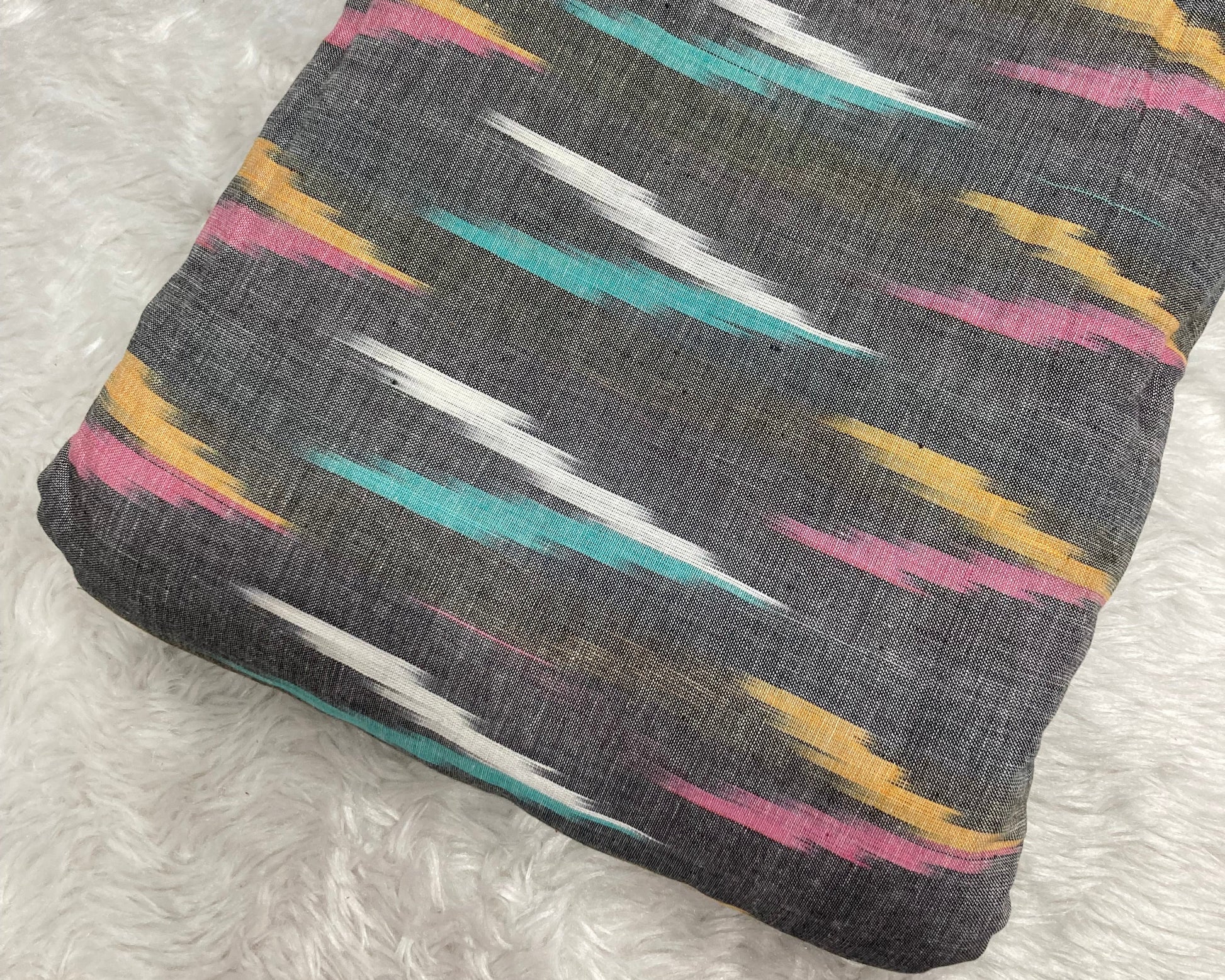 Folded fabric with colorful geometric pattern on a textured surface