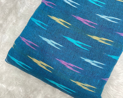 Blue fabric with colorful abstract patterns on a white background