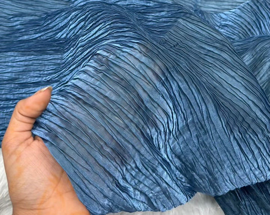 Close-up of blue fabric with a hand holding it