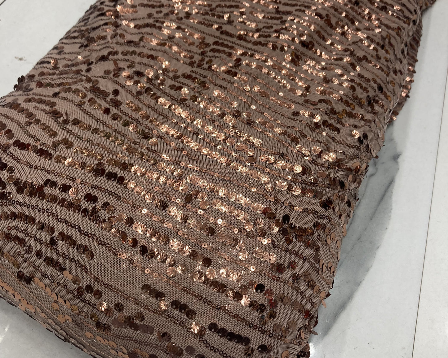 Brown sequined fabric on a white surface